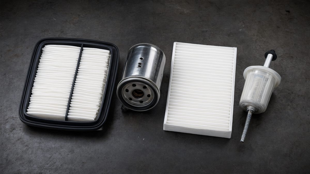 Assortment of air, oil, cabin and fuel filters on a workshop bench (illustrative)